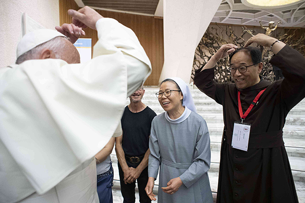 프란치스코 교황이 양손을 머리 위에 올리며 ‘꽃동네 식’ 인사 ‘사랑합니다’로 화답하고 있다. (사진제공=꽃동네)