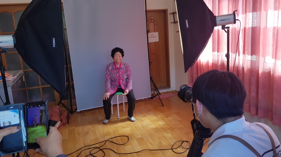 증평정보고 사진동아리 학생이 지역 어르신을 촬영하고 있다.(충북교육청 제공)