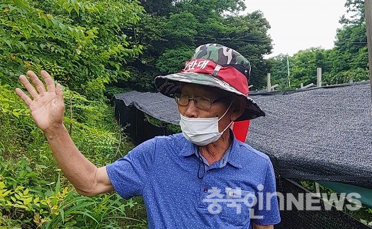 원남면 상노리 남복렬 이장이 음식물 쓰레기 비료가 매립된 곳을 가리키고 있다. (제공=음성타임즈)