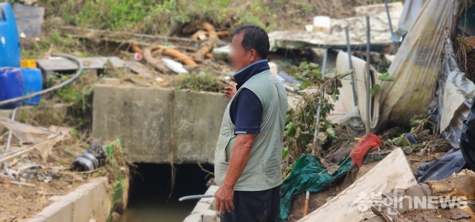 오송읍 호계리 마을 주민이 범람 당시를 설명하고 있다. 수문이 열려 병청천의 물이 들이닥쳤던 수로를 가르키고 있다.