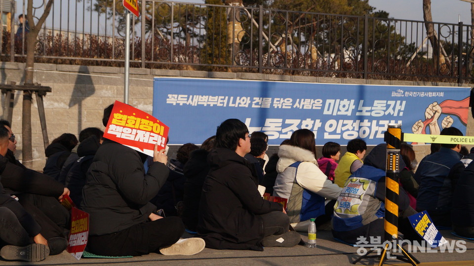 공공운수노조 한국전기공사협회지회 현수막 앞 결의대회 참가자들이 앉아있다.