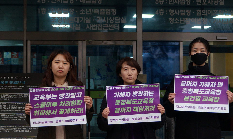 15일 스쿨미투 정보공개 행정소송 판결이 끝난 뒤 충북스쿨미투지지모임과 정치하는엄마들 활동가들이 청주지법 앞에서 피켓을 들고 있다.  