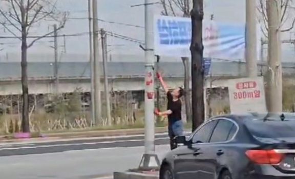 '일찍 일찍 투표하삼' 이란 문구가 새겨진 현삭막을 제거하는 김영석(국민의힘) 충주시의원 (사진=민주당충북도당)