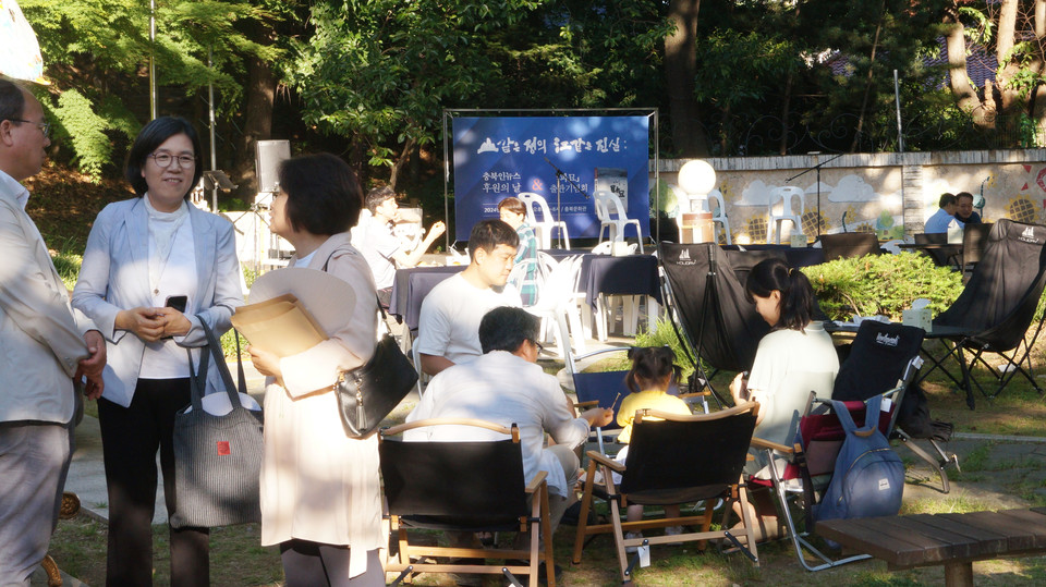 28일 충북문화관 일원에서 진행된 충북인뉴스 창립21주년 후원의날 및 파묘 출판기념회 모습. 잔디숲 곳곳에 놓인 캠핑의자에 참석자들이 앉아 다과를 먹고 있다. (사진=이종은 기자)