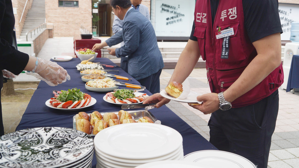 참석자들이 준비된 다과를 다회용기에 담아가고 있다.