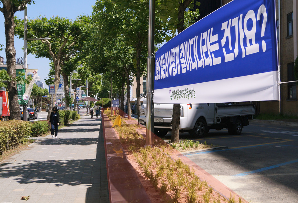 도청 서관 앞 향나무가 식재되어 있던 화단에(빨간 영역) '그늘도 없는데 어떻게 걸어다니라는 건가요?'라고 쓰여진 청주충북환경련 현수막이 걸려있다. 화단에는 이식된 향나무 대신 백문동이 심어져 있다. 