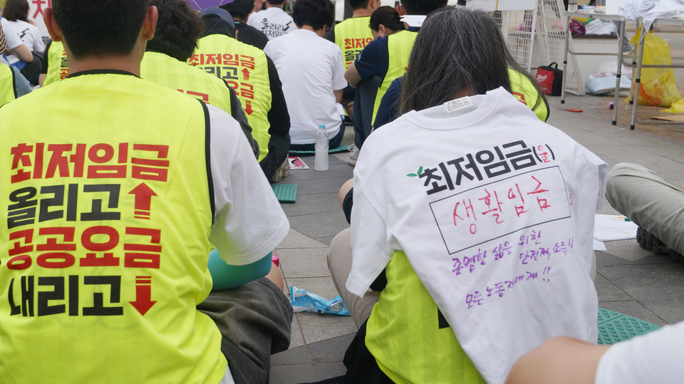 한 참가자가 '존엄한 삶을 위한 안정적 소득을 모든 노동자에게'라고 문구를 적은 티셔츠를 두르고 있다.