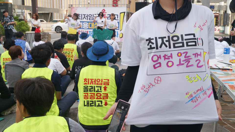 한 참가자가 '최저임금 엄청 오를걸', '작고 귀여운 월급' 등 재치있는 문구를 적은 티셔츠를 입고 있다.