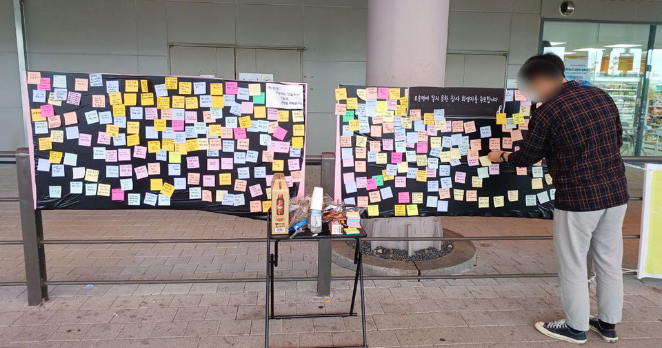 지난해 7월 19일 오송역 버스 정류장에 설치된 오송 참사 시민 추모 게시판. 탁자 위에 꽃다발과 술을 두고간 시민도 있었다. (사진=747 오송역 정류장 모임) 