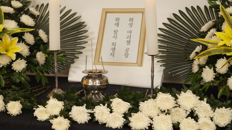 충북 청주시 율량동 소재 이주민노동인권센터 안에 마련된 '화성 아리셀 공장 화재참사 추모분향소' 에 추모객들이 헌화한 국화꽃이 쌓여있다.