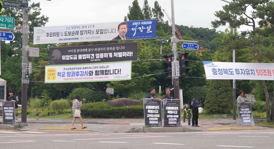 화성 아리셀 참사 추모행동 참가자들이 화재참사 진상규명과 안전 대책 마련을 촉구하는 피켓을 들고 있다. 