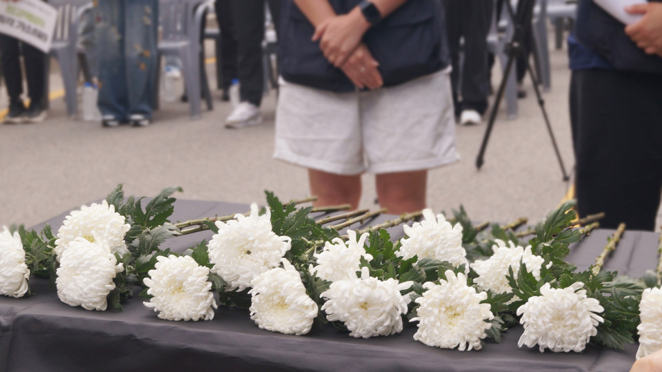 단상 위에 시민들이 헌화한 국화꽃이 놓여있다.