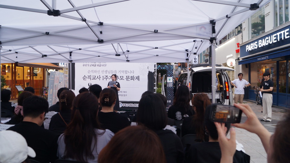 추모 문화제 참가자들이 검은 옷을 입은 채 어깨에 추모 나비를 달고 있다. 