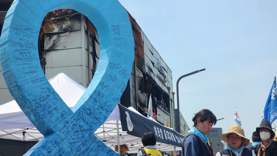 참가자들이 아리셀 앞 파란 리본 조형물에 메세지를 남겼다.