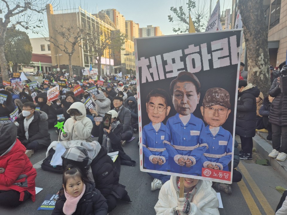 한 시민이 윤석열, 김용현 등 내란범죄 혐의자를 체포하라는 피켓을 들고 있다. (사진=김남균 기자)