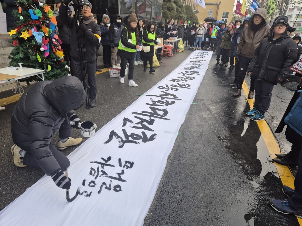 서예가 김성장 작가는 집회현장에서 붓글씨로 “윤석열 즉각퇴진, 국민의힘(짐) 해체, 민주평등 사회대전환”이라는 대형현수막에 작성해 참가자들로부터 박수를 받았다. (사진=김남균 기자)