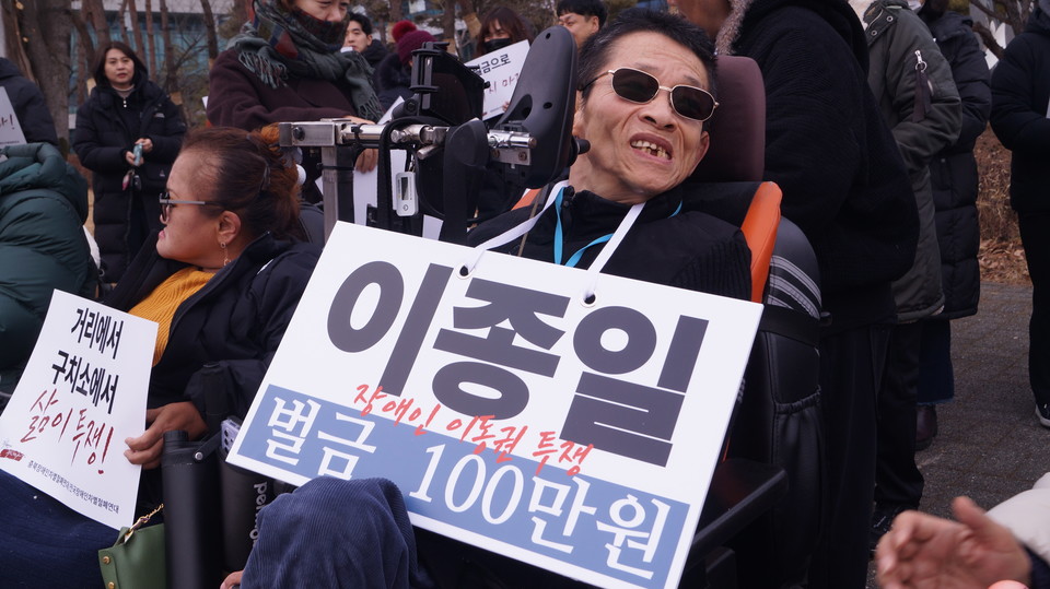 장애인 노역 투쟁에 나선 이종일 충북장차연 상임대표가 목에 벌금 100만원이라고 적힌 피켓을 걸고 있다. (사진=이종은 기자)