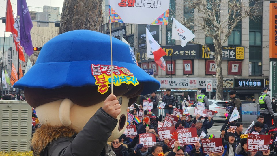 금속노조 마스코트 모자를 쓴 참가자가 구호를 외치고 있다.