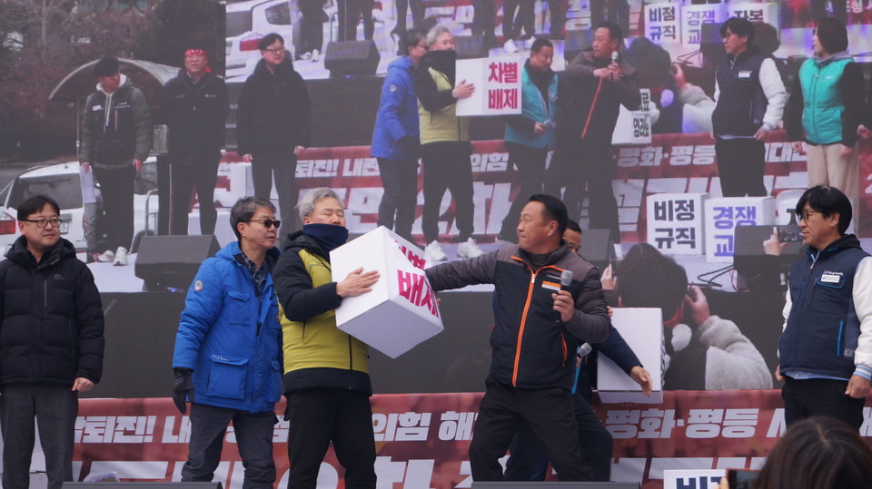 민주노총 지역 산별노조 간부들이 '비정규직', '부자감세', '경쟁교육 철폐' 등 차별 박스를 부수는 퍼포먼스를 하고 있다. 탄핵
