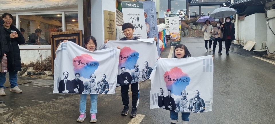 학생들이 충북인뉴스가 기념품으로 증정한 담요를 펼치고 기념 촬영을 하고 있다.