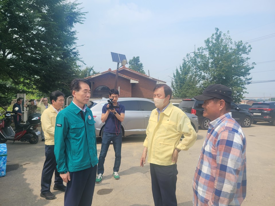 2023년 7월 김성호(왼쪽 앞) 행안부 안전차관도이  청주시 오송읍 김남재 (오른쪽)씨의 밭이 있는 마을회관을 찾아 피해지원을 약속했다. 하지만 1년 8개월이 지난 현재 피해보상은 전혀 이뤄지지 않고 있다. (사진=김남균 기자)