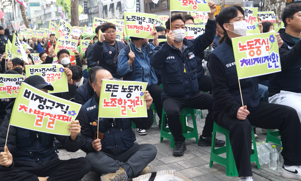 참가자들이 노동중심 체제전환 의제가 적힌 깃발을 들고 있다.