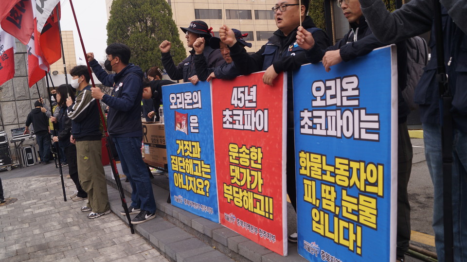 화물연대 충북지역본부가 오리온 청주공장 조합원 집단해고를 규탄하는 피켓을 들고 있다. 