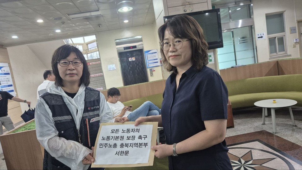 민주노총 충북지역본부 박옥주 본부장이 노동부 청주지청 측에 서한문을 전달하는 모습.(민주노총 충북지역본부 제공)